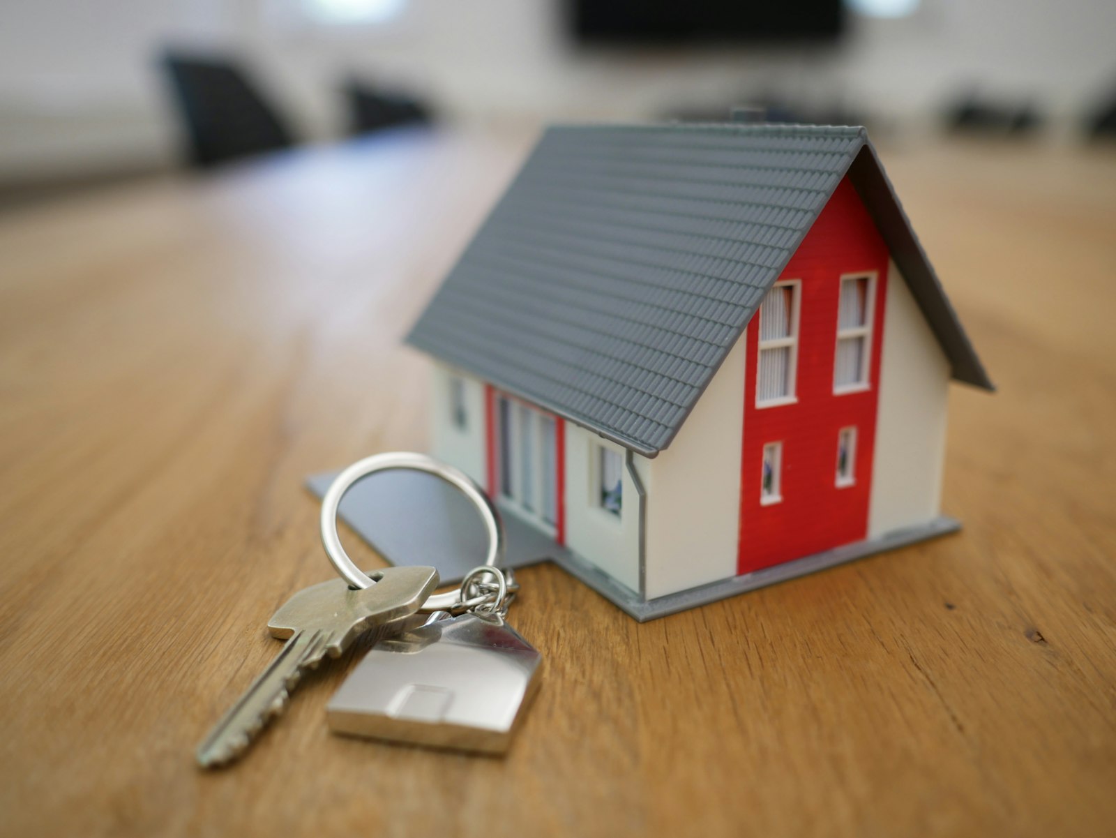 Model house and keys on a wooden table